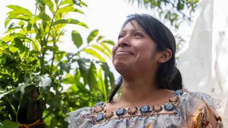 Woman in outdoor space with chin up facing the sky