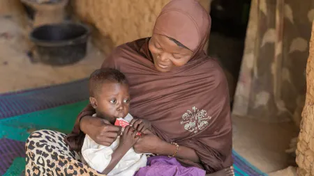 Nigerian mother, Hauwa, feeding her son a ready to use therapeutic food (RUTF) to combat child malnutrition
