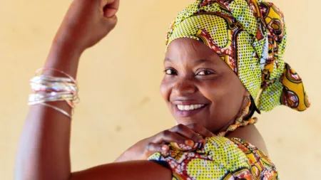 Woman showing her triceps while smiling at the camera.