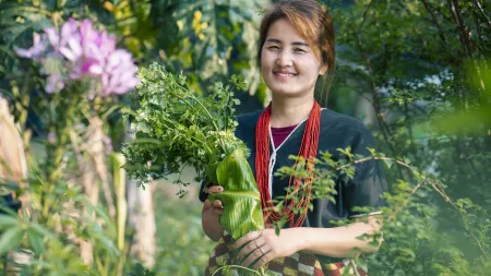 Siriporn, a farmer in Mae Chaem, tends her garden using sustainable practices that support her family and local market.