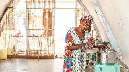 Rosemary cooks from a solar-powered community kitchen at the Kagoma Reception Centre.