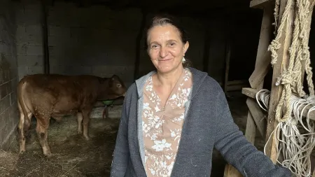 Makfire stands on her farm in Kosovo, where she has rebuilt her life through determination and a deep love for farming.