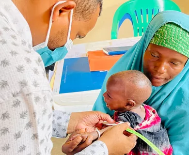 Doctor seeing baby being held by the mother in Somalia