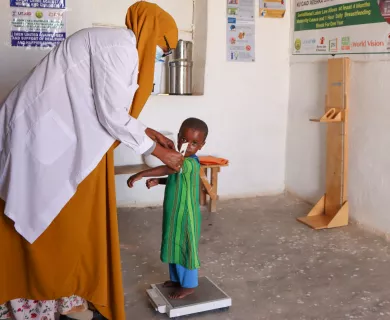 Health officer checks child weight in Somalia