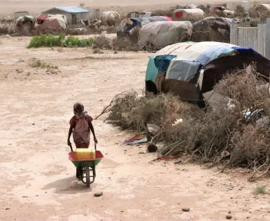 Woman carrying trolley in IDP camp in Somalia