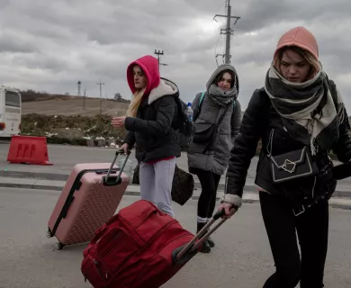 Three women with winter clothes and carrying luggage