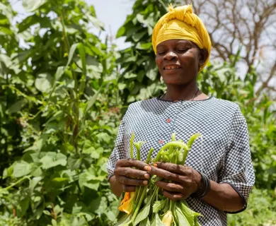 Tanzania_Woman holding plants on farm