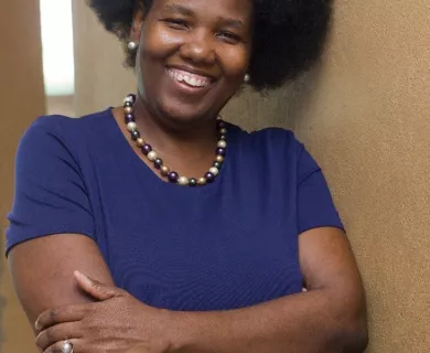 Woman smiling at camera, wearing blue shirt
