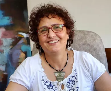 Headshot of woman smiling to the camera, wearing glasses