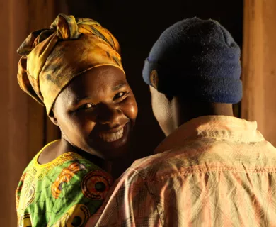 Rwanda_Smiling woman looking back at camera hugging man
