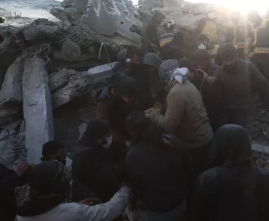 Syrian emergency workers and civilians moving rubble