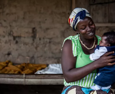 Sierra Leone_Woman with green shirt smiling and holding new born