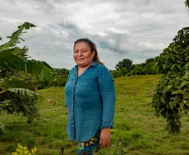 Honduras_Woman in blue shirt standing in front of field
