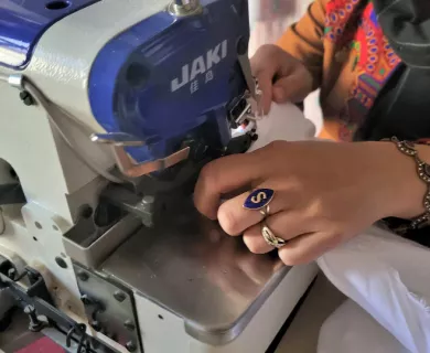 Afghanistan_Woman's hands holding fabric in sewing machine