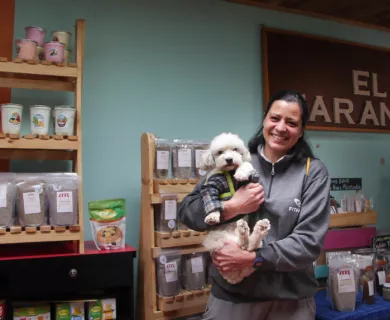 Colombia_Woman in small shop holding white dog