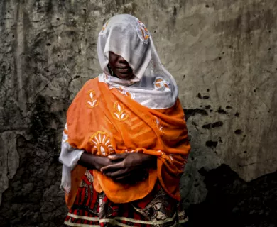 Nigeria_Woman in orange shawl and white scarf disguising her face