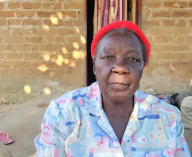 Zambia_Old lady with red beanie and powder blue and pink blouse
