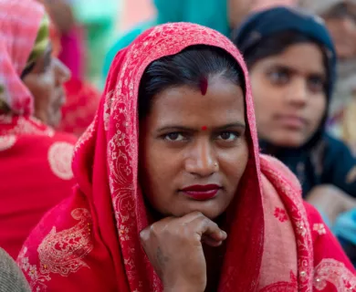 India_Woman with red bindi and red sari looking into camera smirking