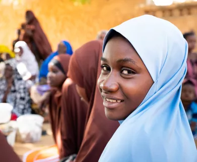 Girl with blue veil turning to camera smiling