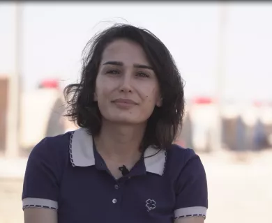 Syria_Woman in blue shirt smiling at camera