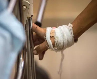 Hand with bandage holding gurney