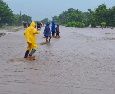People wearing rain coats in flooded street