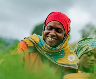 Woman wearing red headband smiling while harvesting